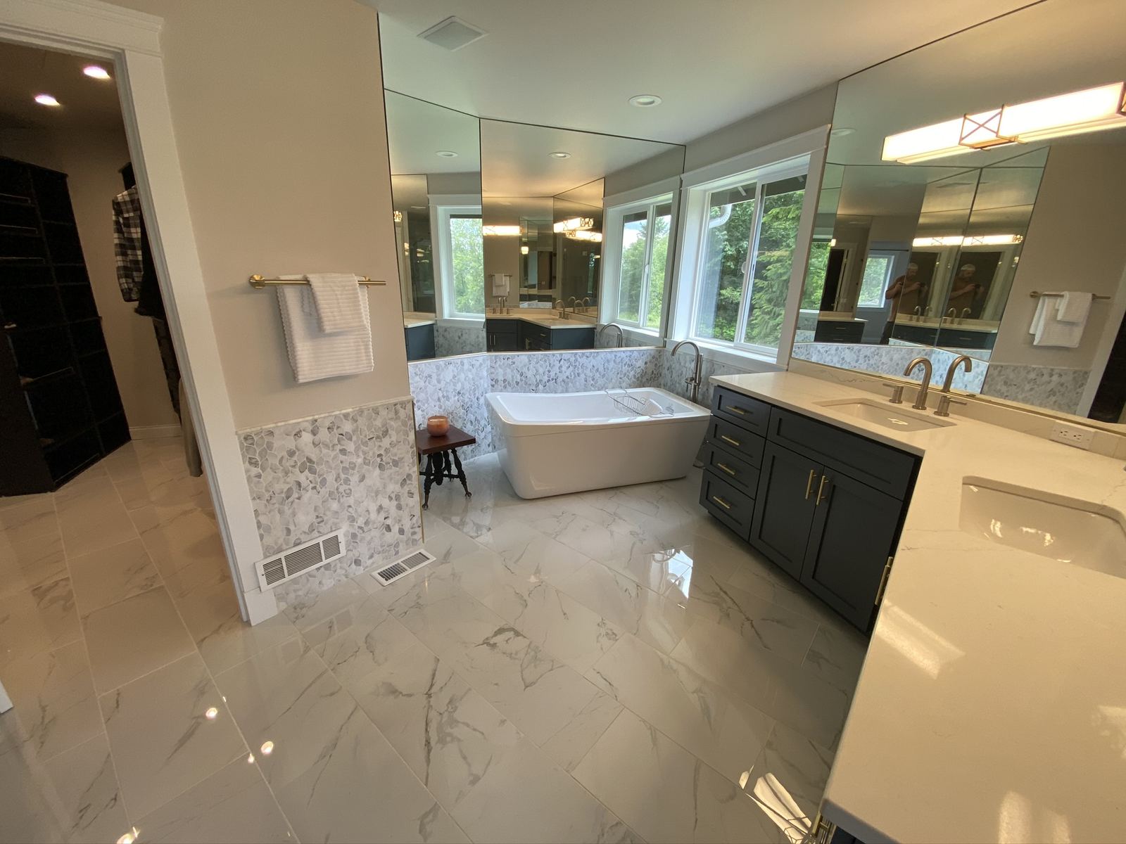 Remodeled bathroom with glass walk-in shower and dark vanity cabinetry