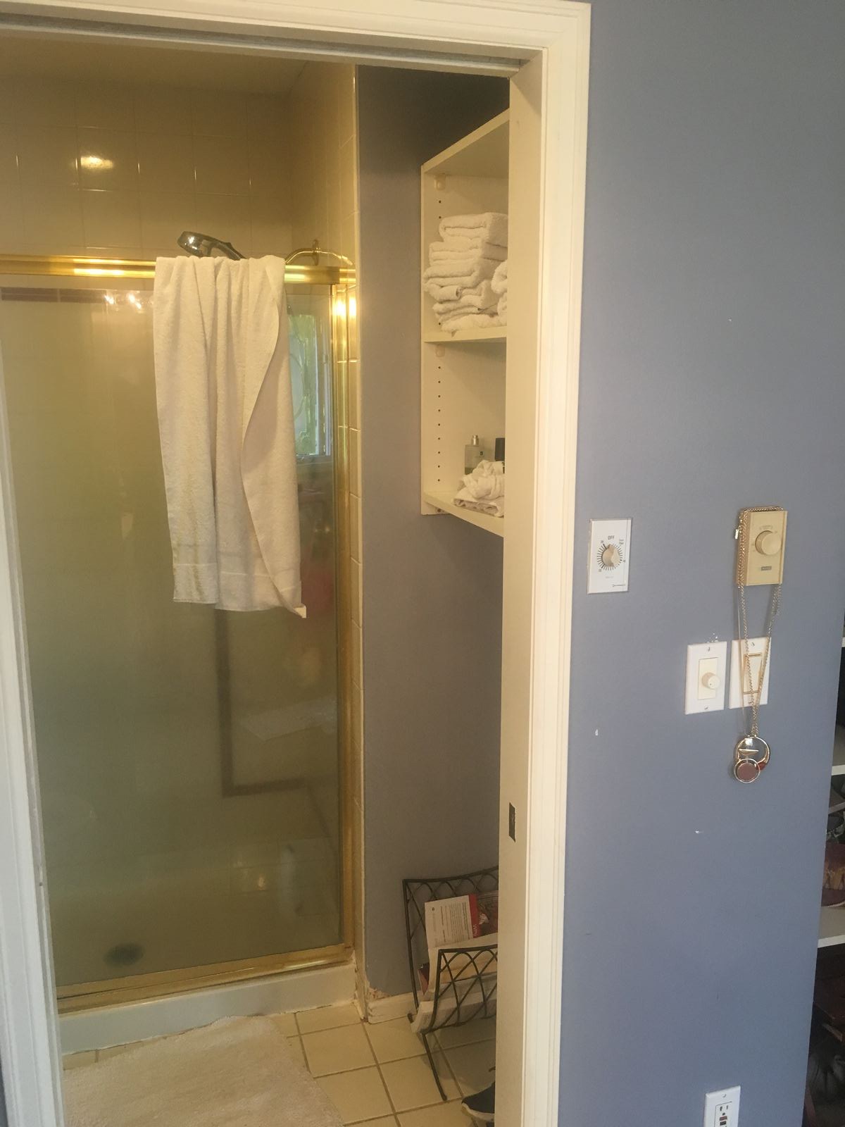 Original stall shower and linen shelving before remodel