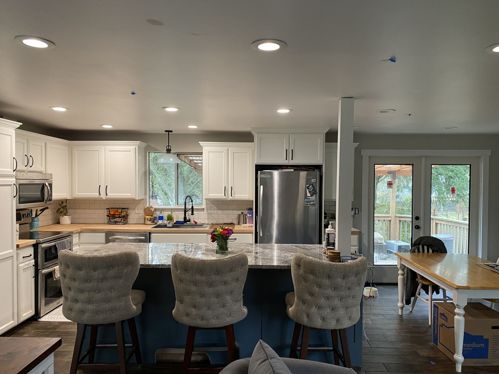 Remodeled kitchen with white cabinets, butcherblock counters, and subway tile backsplash