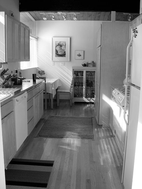 Original galley kitchen with light wood cabinets before remodel