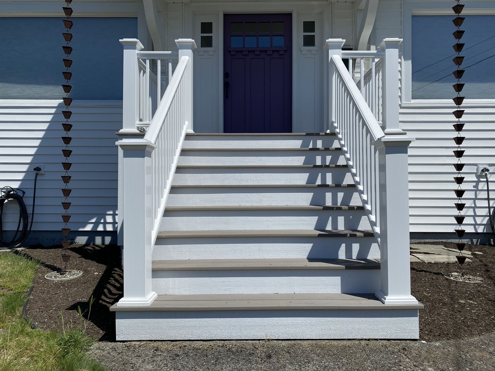 Front entry stairs with white painted railings and rain chains