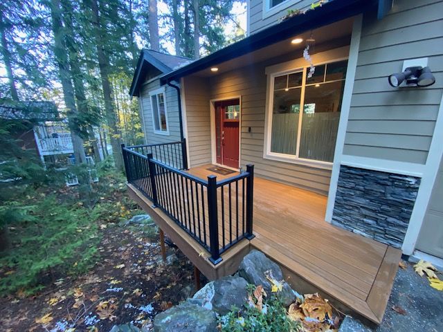 Wooded-lot deck with black metal railings at dusk
