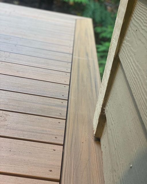 Close-up of composite decking board lines against the house siding