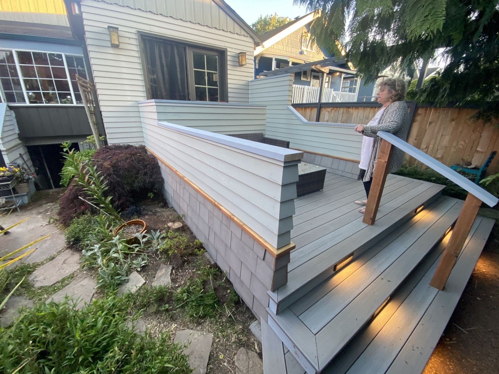 Elevated deck with solid siding-clad walls and built-in step lighting