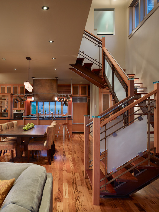 Open stairway with wood treads and metal rail, overlooking the dining area